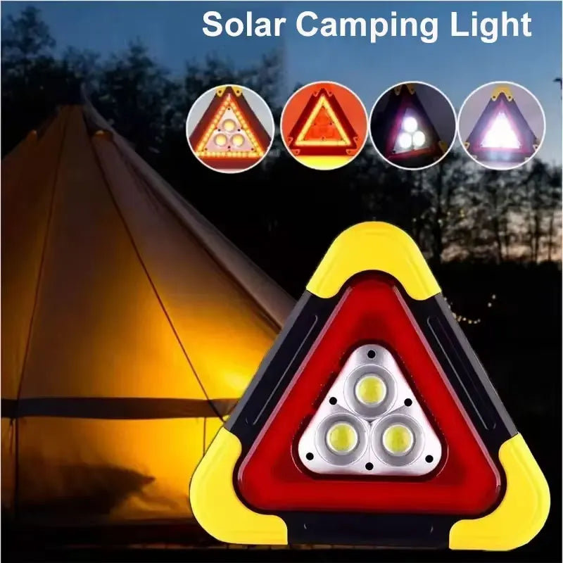 A triangular solar camping light with three LED lights illuminating a tent in the dark.