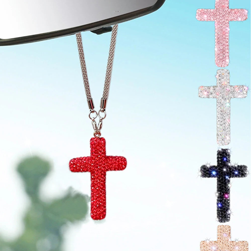 A red cross pendant on a silver chain hanging in front of a mirror.