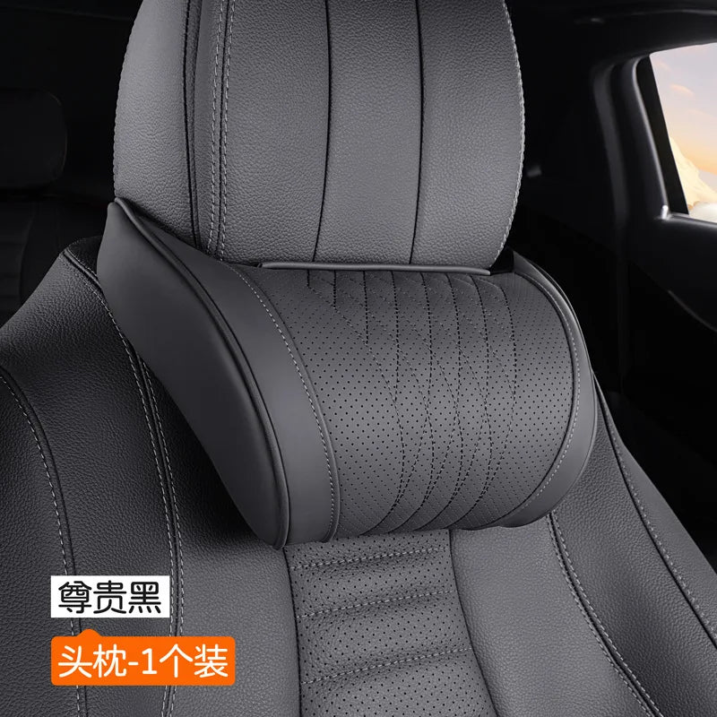Gray memory foam car headrest with a black leather cover installed in a vehicle seat.