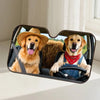 A golden retriever wearing a straw hat and a red bandana is visible inside a car windshield sunshade.