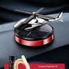 Parfum voiture solaire noir rotatif avec base rouge et détails d'huile essentielle sur une surface sombre.