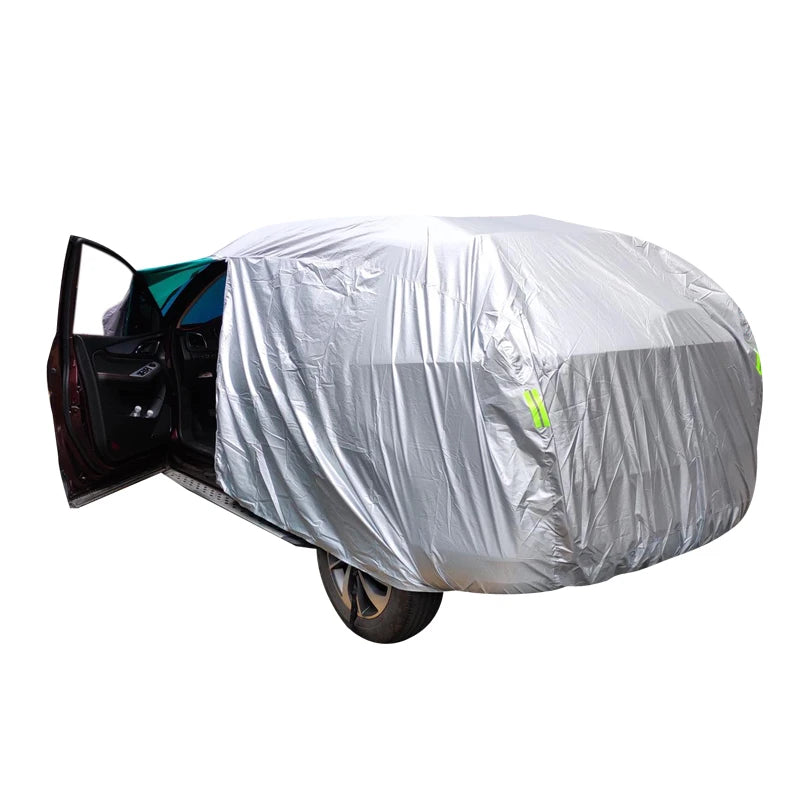 A silver universal all-weather car cover is placed over a dark-colored SUV or sedan.