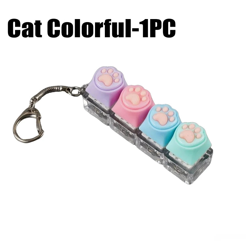 A clear acrylic keychain featuring five colorful cat paw shaped silicone fidget toys.