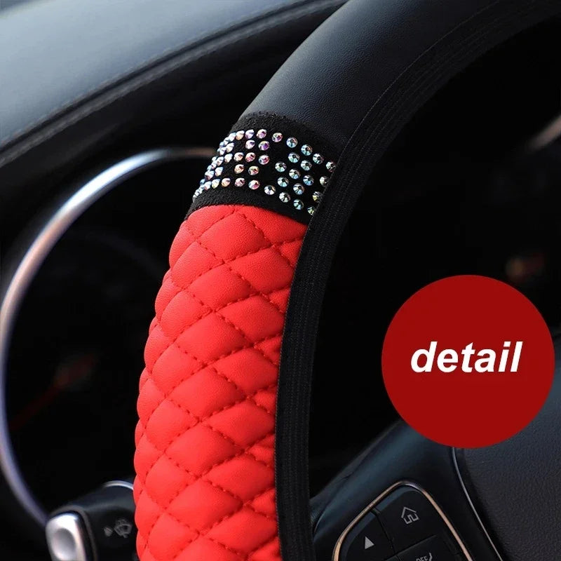 Close-up of a red quilted leather steering wheel cover with silver studs on the rim.