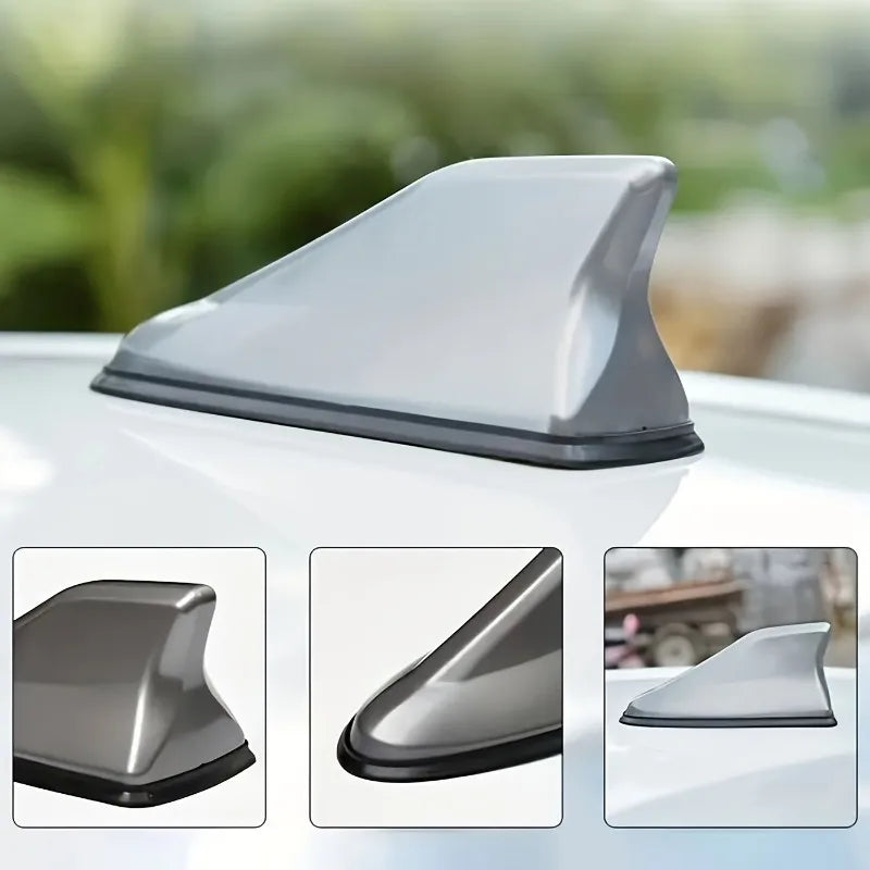 A silver shark fin universal car antenna amplifier shown in three views on a white surface.