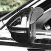 A close-up view of a black universal car rearview mirror rain and dust visor installed on a vehicle.