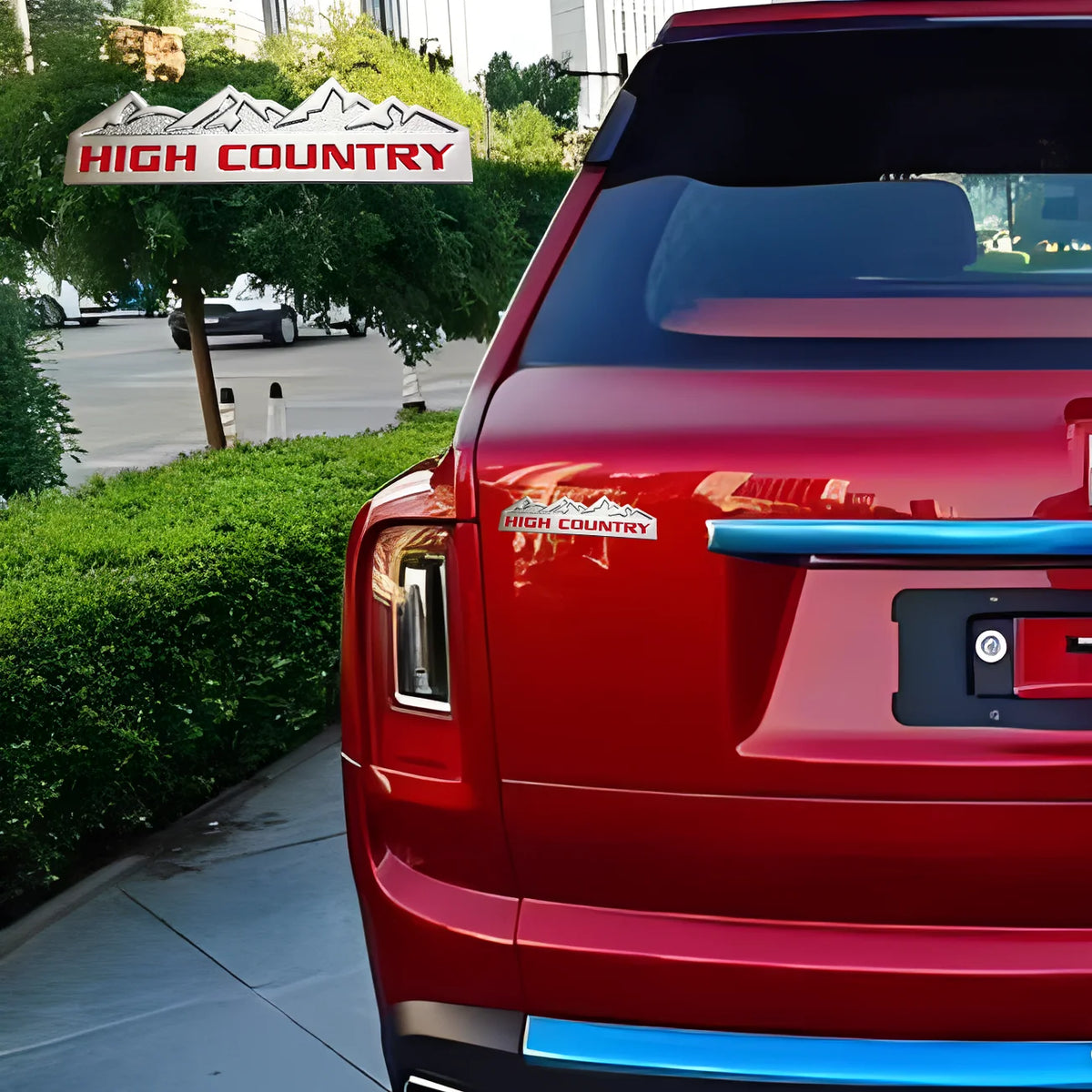 A close-up view of a red truck or car with a High Country decal on the rear, parked outdoors.