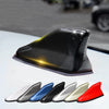 A collection of various colored carbon fiber look roof mount antennas displayed on a white surface.