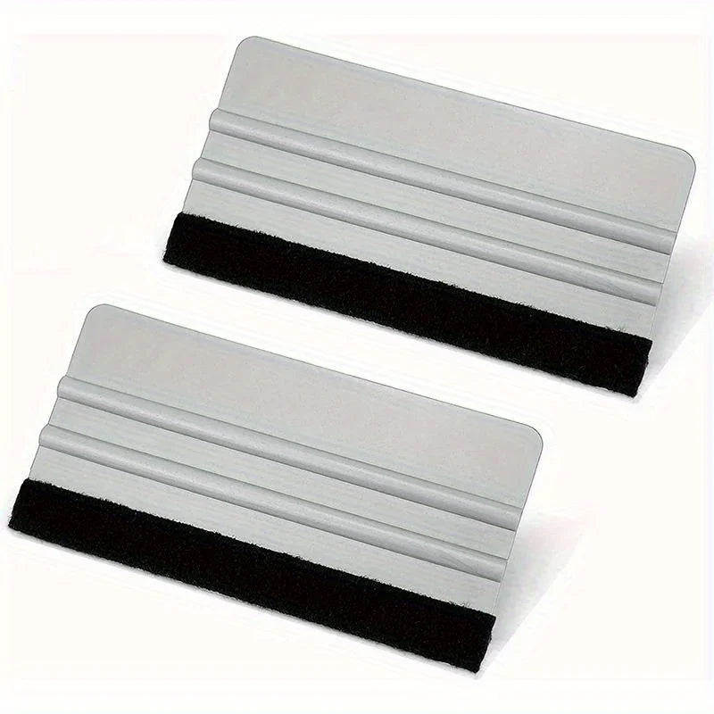 A precision scratch-free decal applicator tool shown in two views, featuring a silver plastic body and a black rubber grip.