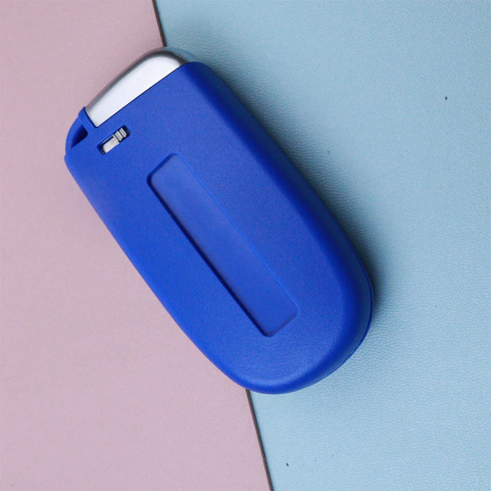 A blue car key fob shell replacement housing resting on a light pink and blue background.