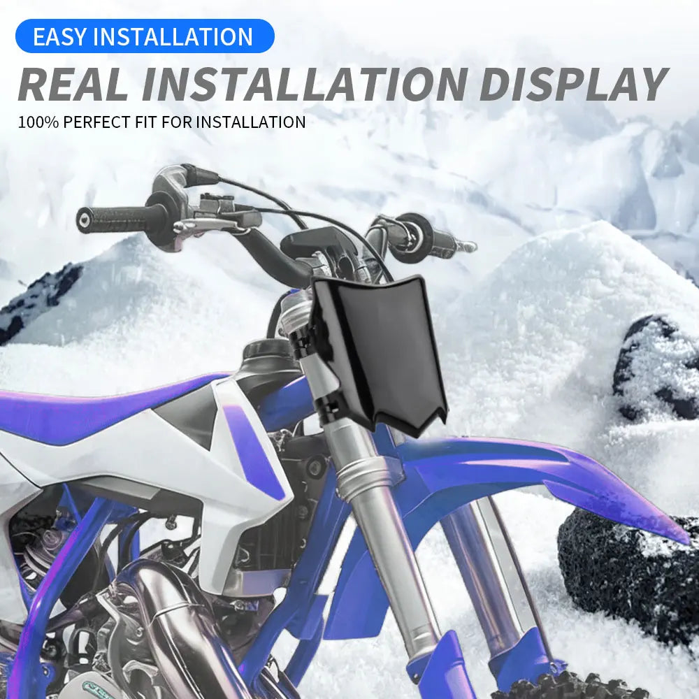 A black motorcycle number plate cover is installed on a purple and white electric bike in a snowy outdoor setting.