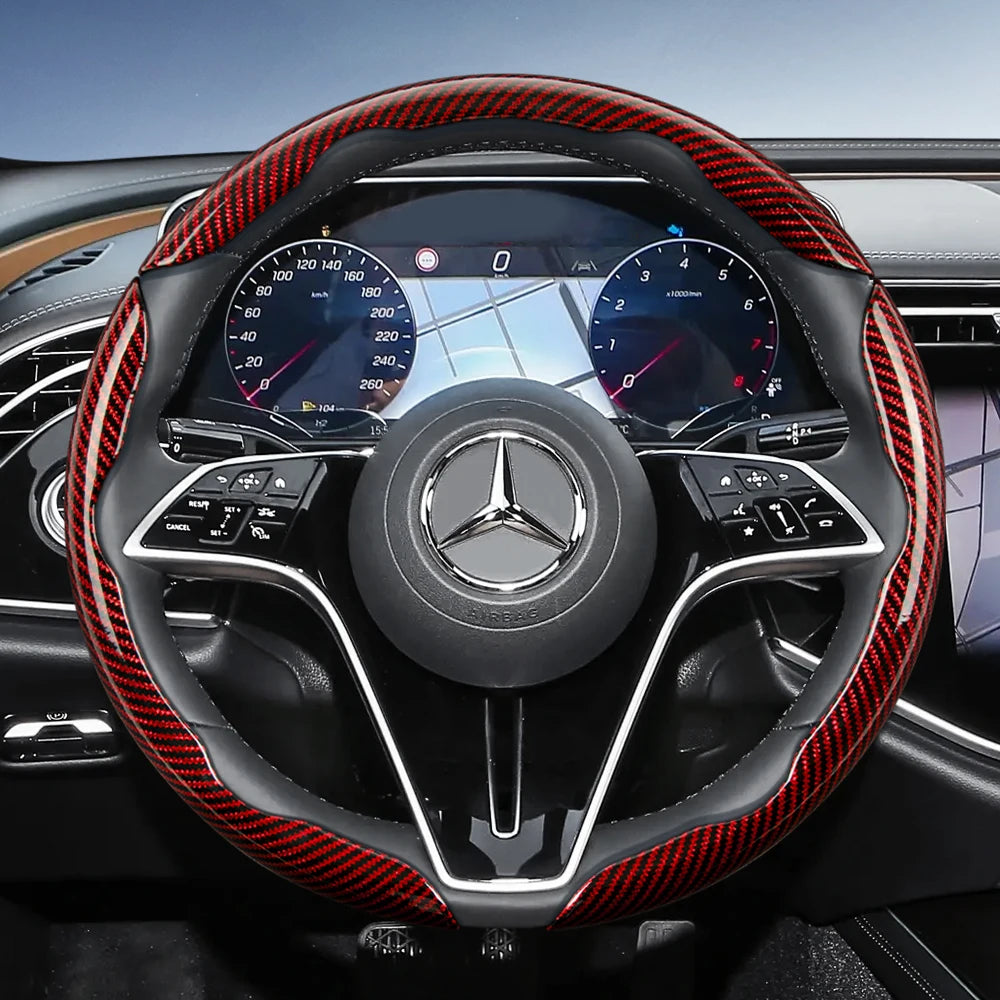 Close-up view of a black steering wheel with red carbon fiber texture covers and digital instrument cluster.