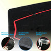 Close-up view of a black custom dashboard mat with a red edge, showing its texture and layered design.