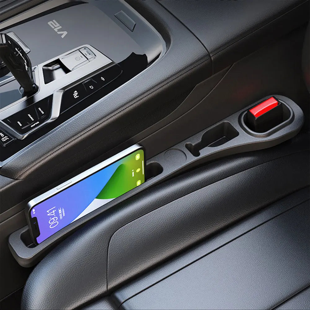 A close-up view of a car seat gap filler organizer with a smartphone resting inside.