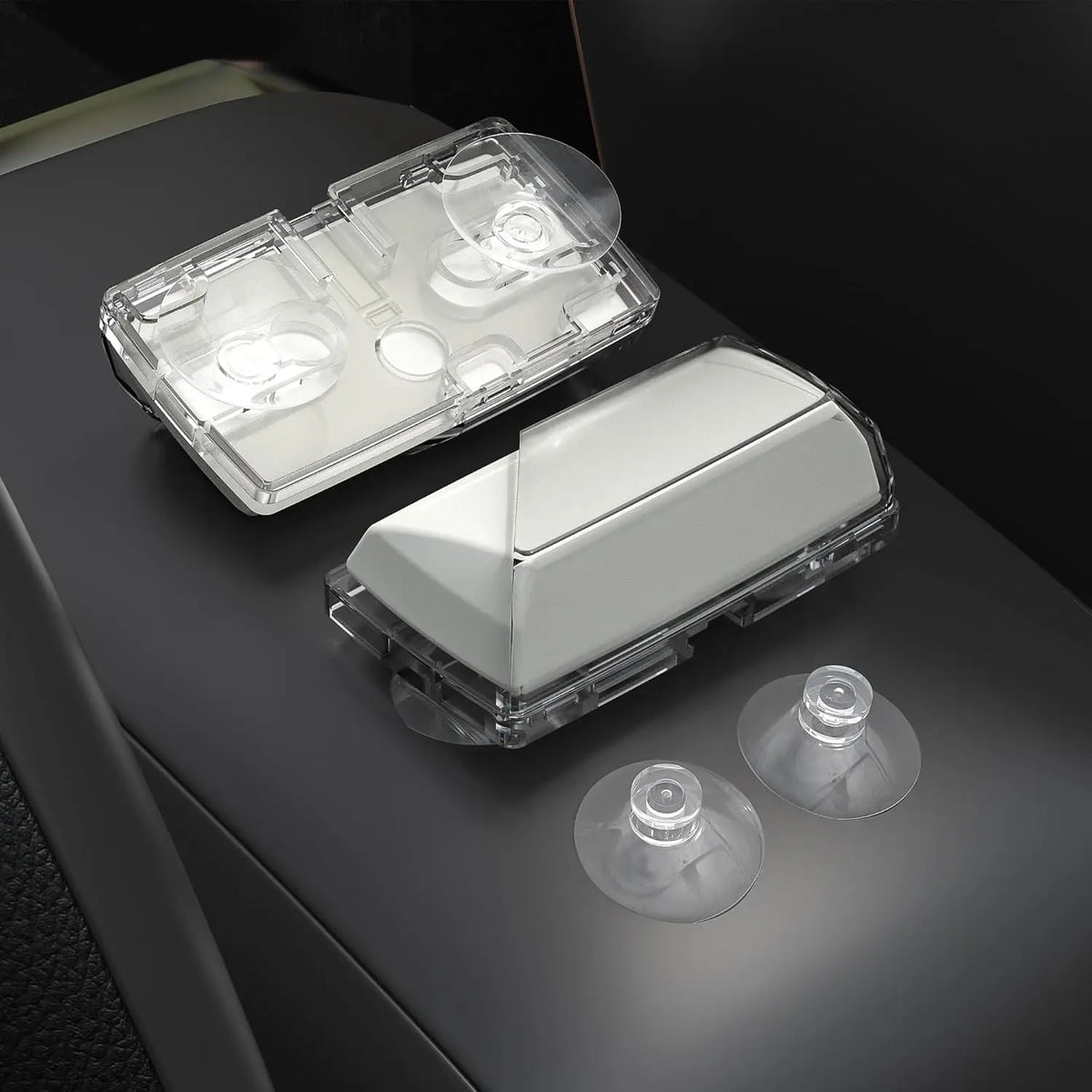 Clear plastic EZ-Pass holder and suction mount device resting on a dark surface.