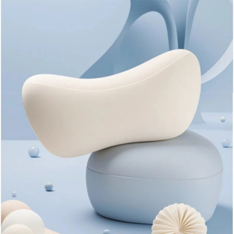 A light beige car neck pillow resting on a light blue surface with soft, flowing background elements.