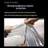 Hands are applying a clear tint film to a car headlight or taillight to repair scratches.