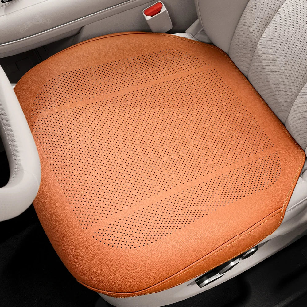An orange breathable car seat cushion is shown placed in a white car seat interior.