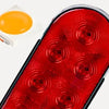 لقطة مقربة لمصباح خلفي لحاويات LED أحمر بعدة عدسات دائرية ومصدر ضوء برتقالي قريب.