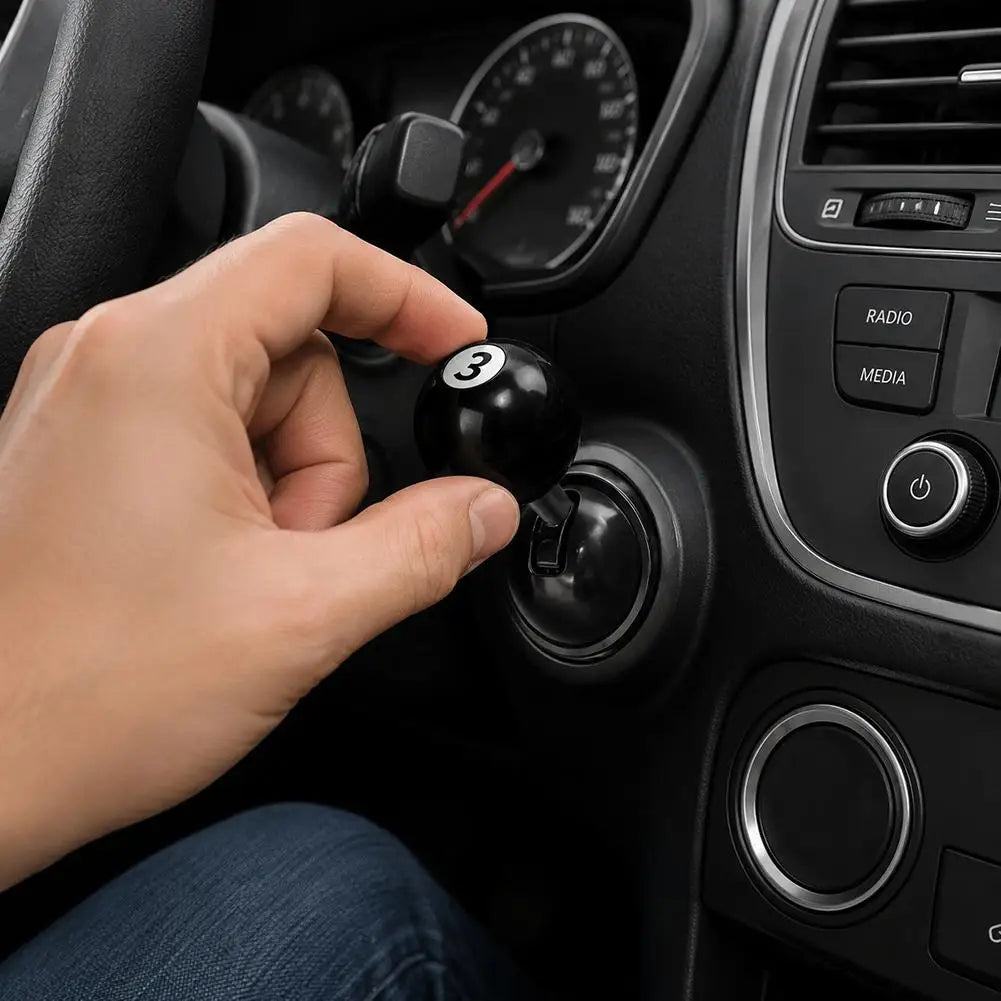 A hand is pressing a button on a car start button joystick located in the vehicle's interior dashboard.