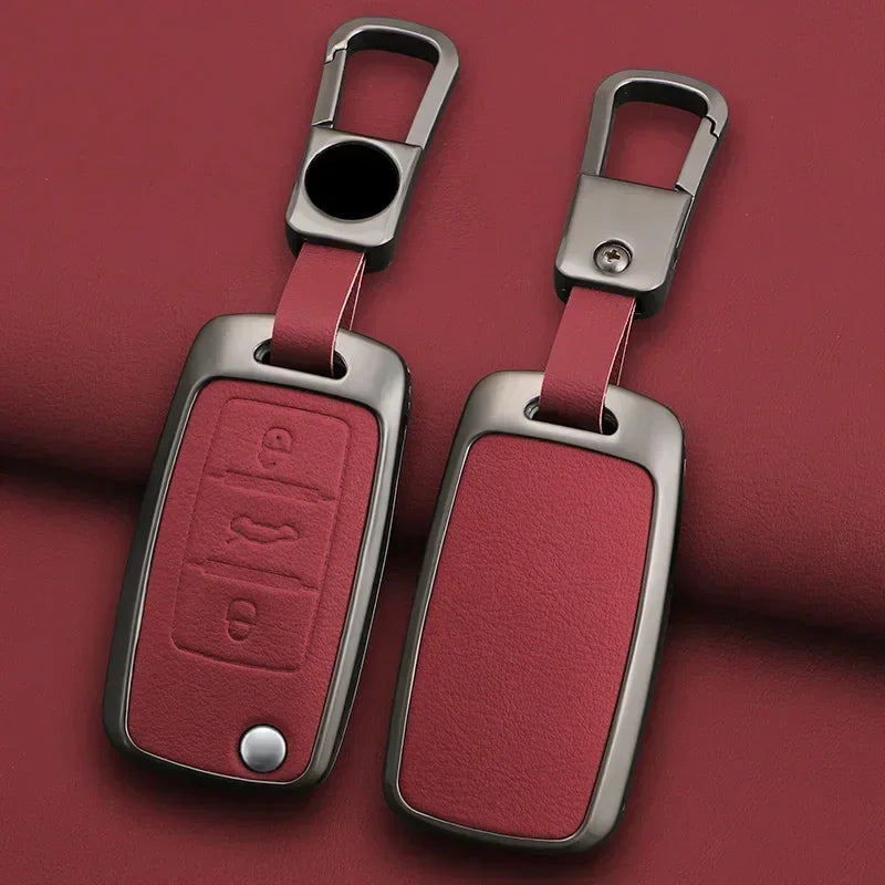 Une paire de cache-clés métalliques avec des sangles en cuir rose et des étiquettes métalliques rectangulaires.