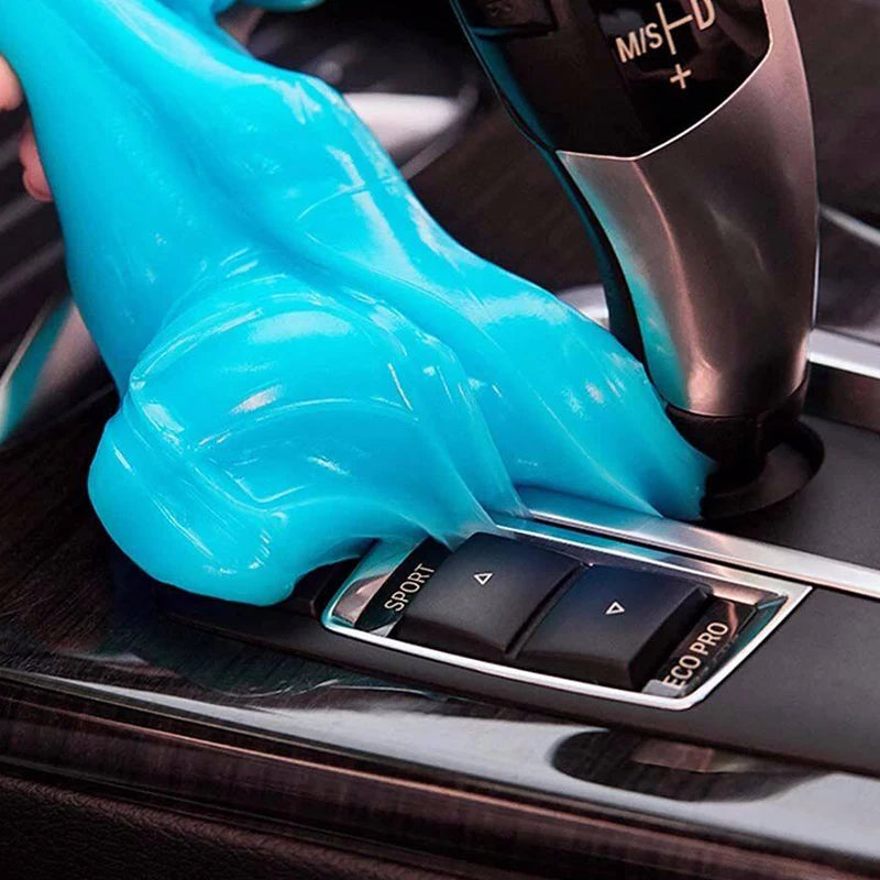 A hand wearing bright blue silicone gel is being cleaned on a black device for household and car surfaces.