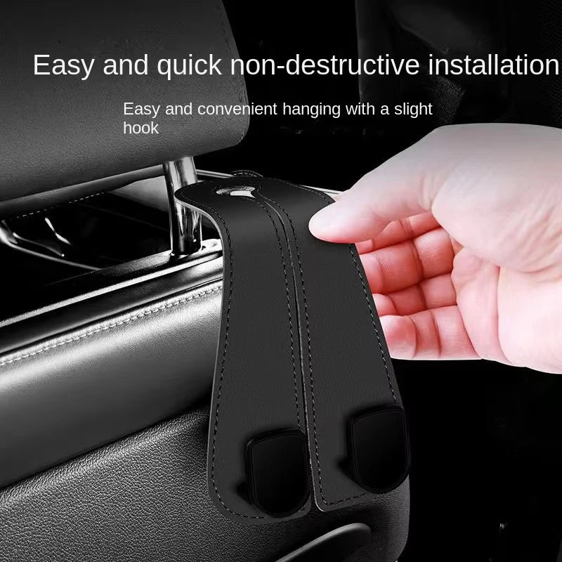 A hand is installing a non-destructive car headrest hook for bag organization into a car seat.