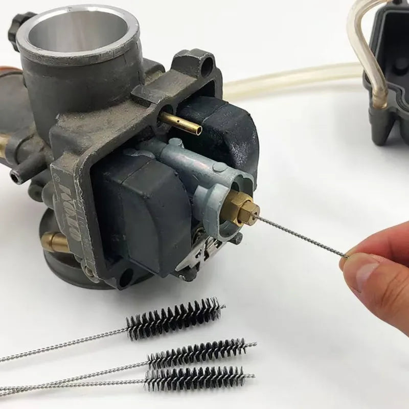 A tool set for carburetor cleaning and maintenance, showing a metal nozzle and several wire brushes.