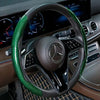 Nahaufnahme eines schwarzen Lenkrads mit grünem Laser-Carbonfaser-Wrap in einer Luxusautosinterieur.