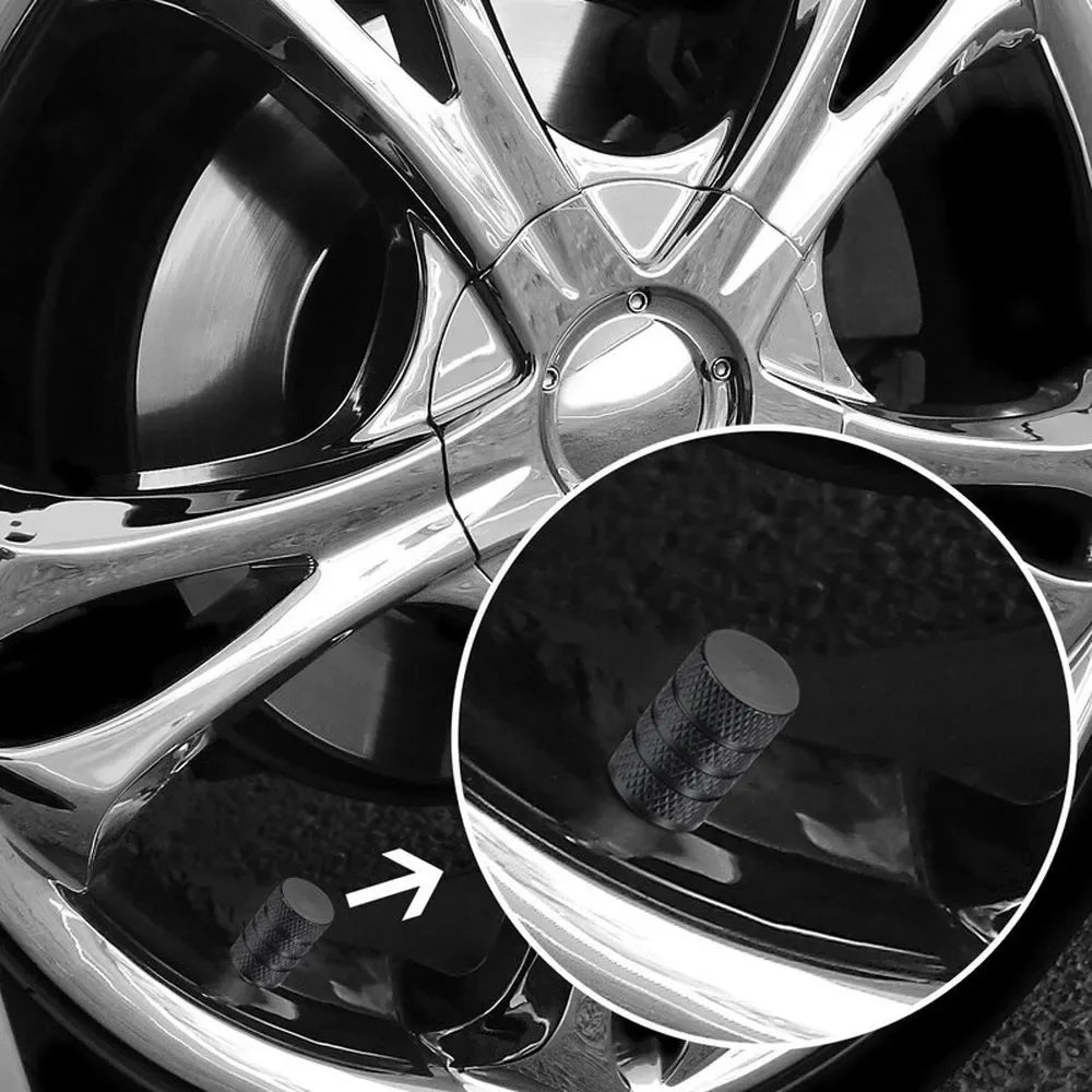 Close-up view of a set of aluminum tire valve caps mounted on a wheel rim.