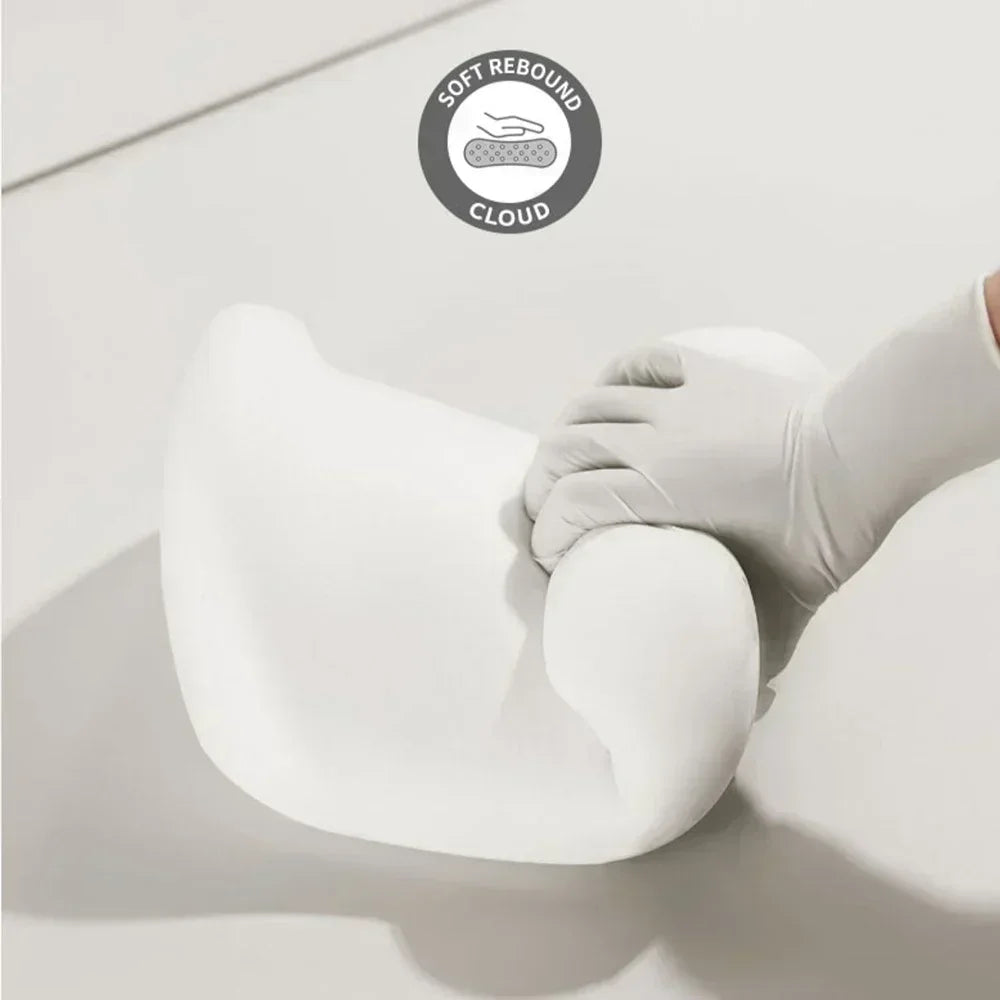A hand is gently pressing a white memory foam pillow, demonstrating its soft rebound features.