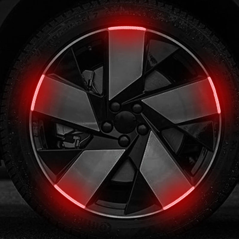Gros plan sur une roue de voiture ou de moto avec un éclairage LED rouge illuminant le design des rayons.