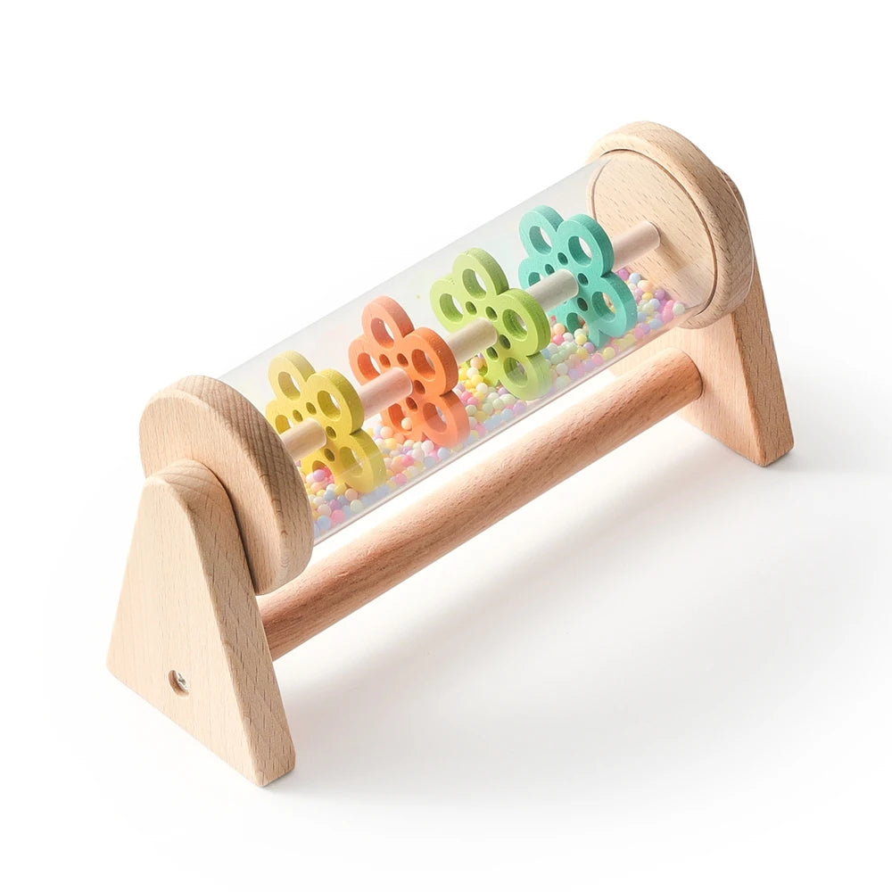 A wooden rainmaker musical toy with colorful plastic raindrops mounted on a wooden frame.