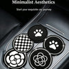Four circular coasters featuring paw prints and floral designs placed in a car cup holder.
