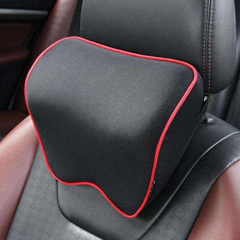 Black memory foam car headrest neck pillow with a red trim, shown in a vehicle seat.