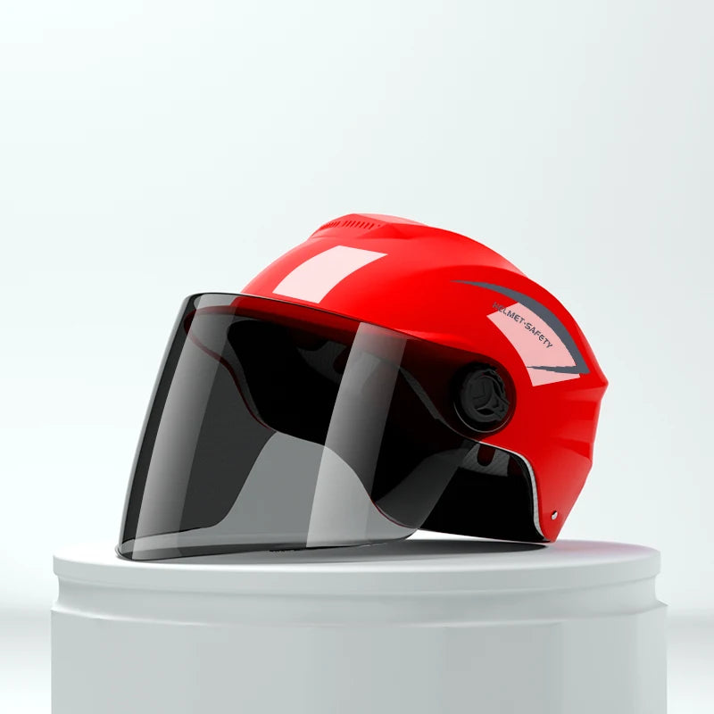 A red lightweight rainproof half helmet with a clear visor displayed on a white stand.