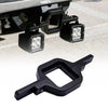 Black dual LED pod mount brackets for a 2.5-inch tow hitch visible on a vehicle frame.