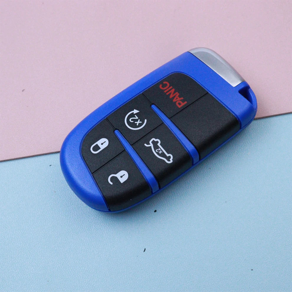 A blue car key fob shell replacement housing with panic and unlock buttons resting on a light pink surface.