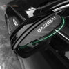 Close-up of carbon fiber rain guards installed on the side mirrors of a black Nissan Qashqai.