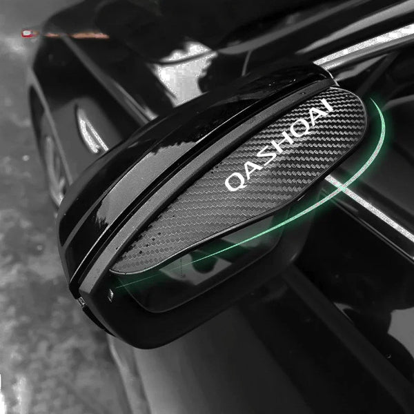 Close-up of carbon fiber rain guards installed on the side mirrors of a black Nissan Qashqai.
