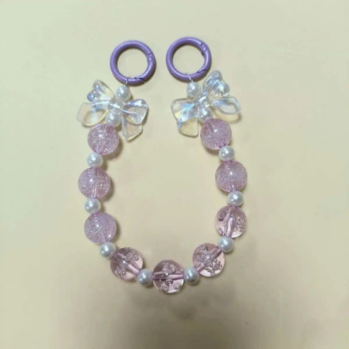 Purple lanyard with a white flower charm and round pink beads for phone anti-loss