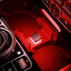 Close-up view of a red car interior featuring ambient LED lights and controls.