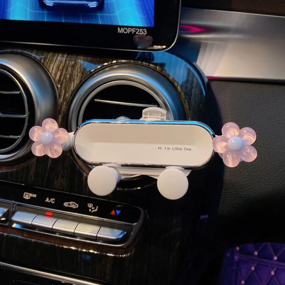 Support de téléphone blanc avec attaches florales roses, monté sur une radio ou un tableau de bord de voiture.