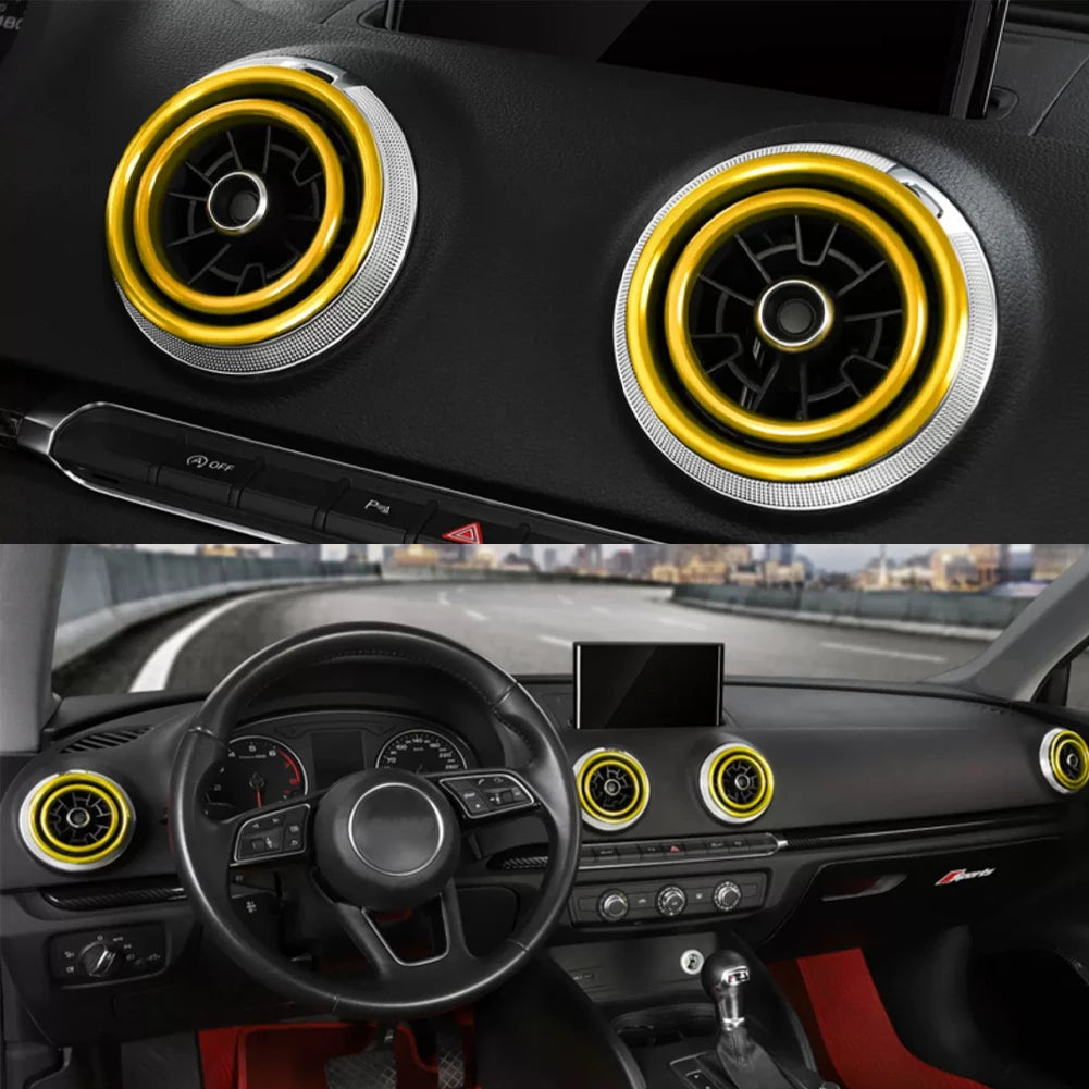 Close-up view of interior air vent trim covers in gold and silver on a car dashboard.