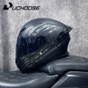 Un casque de moto DOT noir et modulaire est exposé sur un siège de moto.