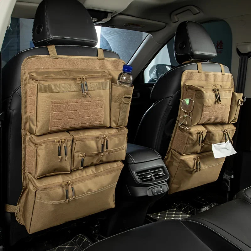 A tan tactical luggage organizer bag with multiple compartments is visible in the back seat of a car, positioned over a black