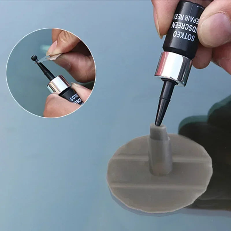 A close-up of a windshield crack repair kit showing a tool being used to fix damage on a glass surface.