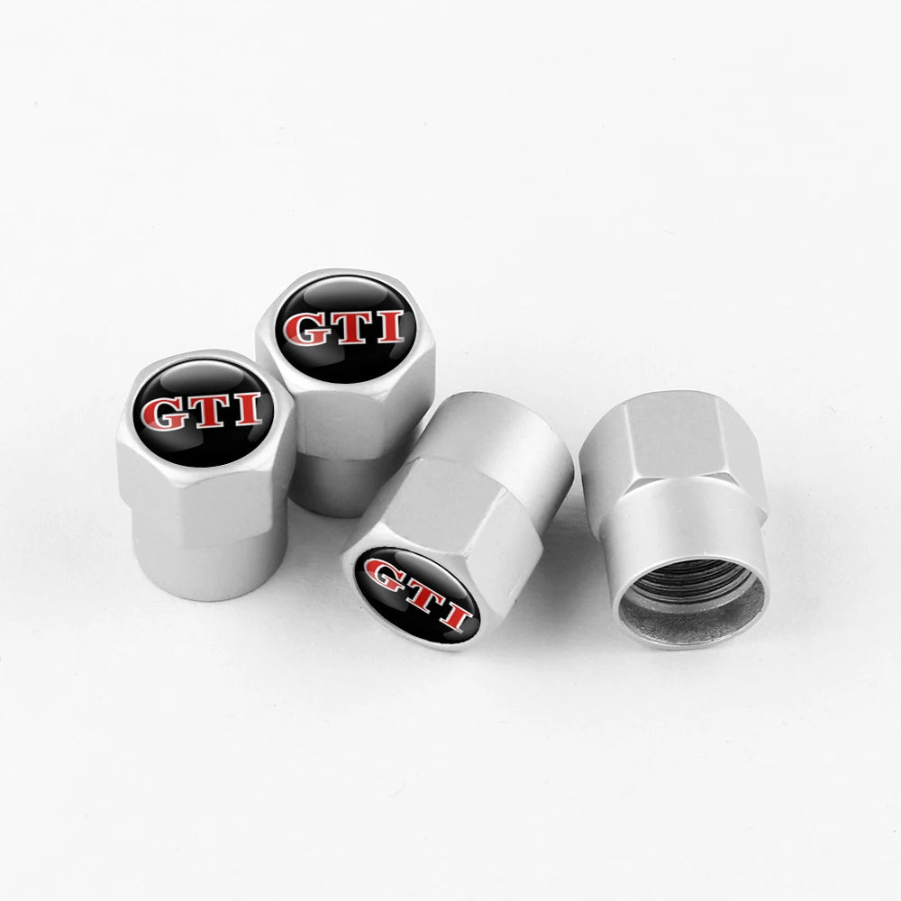 Three metal tire valve caps with black and red GTI lettering displayed on a white background.
