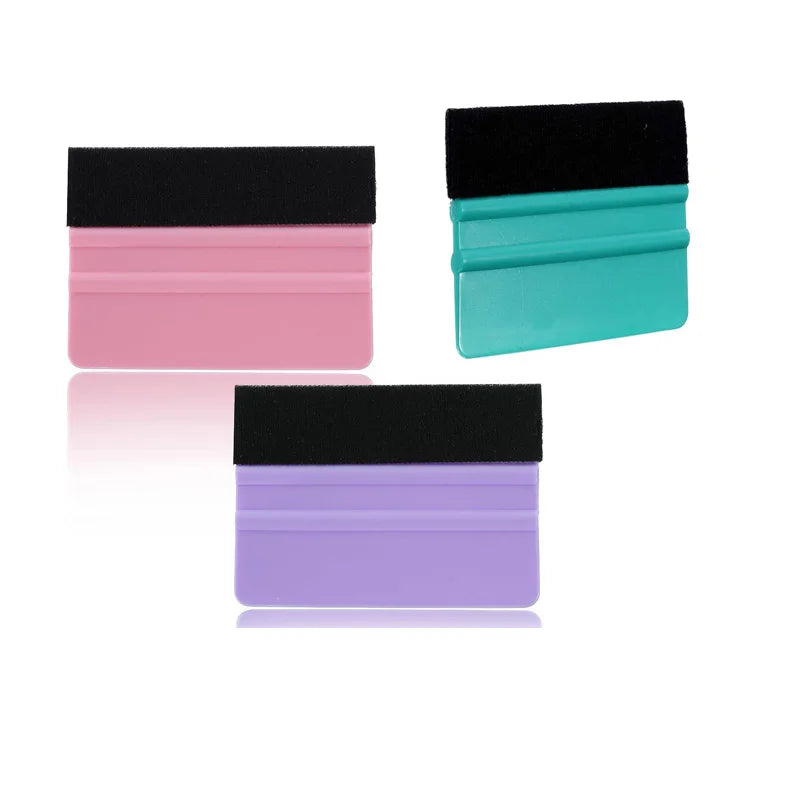 A set of four felt squeegee tools in black, pink, teal, and purple for removing vinyl decals and film.