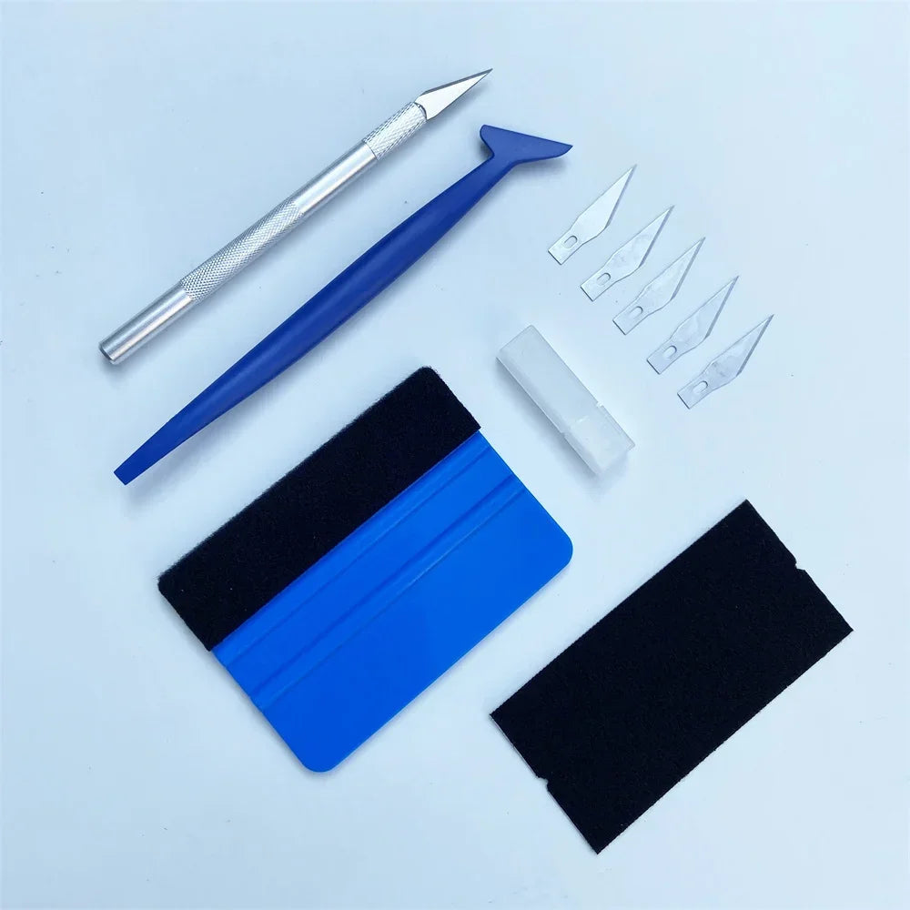 A set of vinyl wrap tools including a stylus, blades, and black and blue protective film.